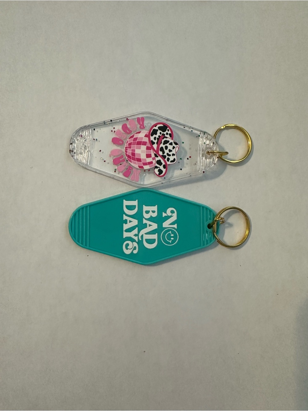 Teal 'No Bad Days' Motel Keychain + Pink Glitter Beach Cow Keychain - Set of 2